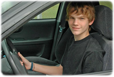 Male teenage driver in black sports car